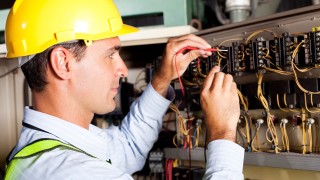 Arbeiten am Stromkasten Elektroinstallateur arbeitet an Stromkasten